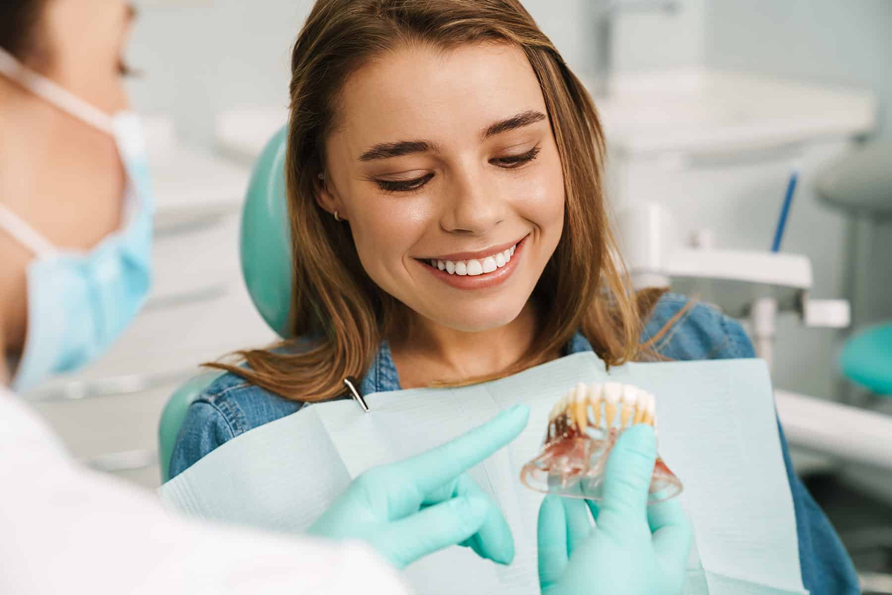 Young woman looking at dental implant example