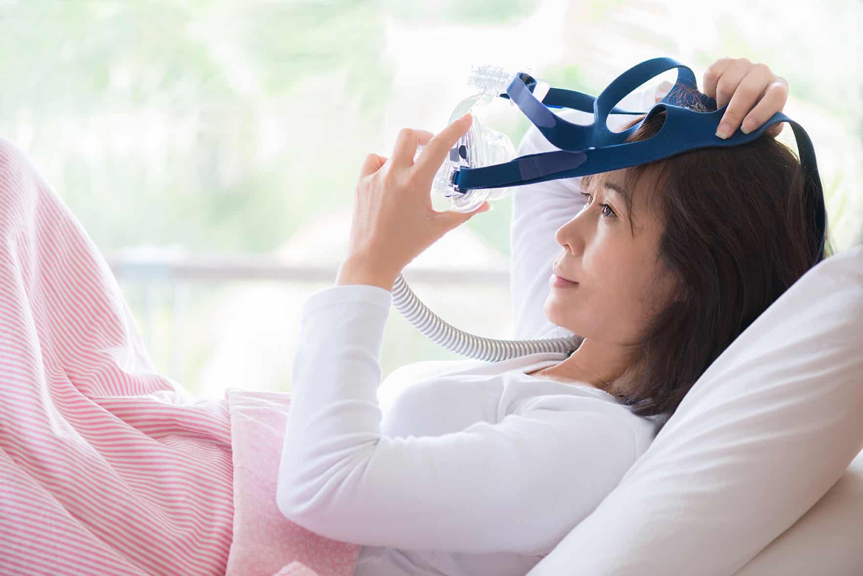 woman placing a cpap machine on her head from o'shee family dentistry